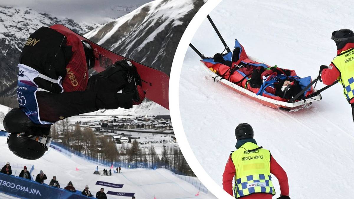 Narciarz wykonujący ewolucję w powietrzu na tle ośnieżonych g&oacute;r i stoku narciarskiego z widzami, obok widoczni ratownicy niosący osobę na noszach.