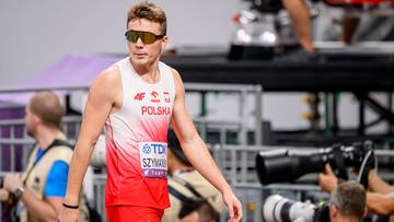 Polski lekkoatleta w biało-czerwonej koszulce i okularach przeciwsłonecznych podczas zawod&oacute;w lekkoatletycznych.