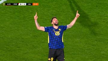 Piłkarz w niebieskiej koszulce z żółtymi elementami świętuje zdobycie bramki, podnosząc ręce do góry i wskazując palcami w niebo. Na górze ekranu widoczny jest wynik meczu ZVE 0 - 1 LIL.