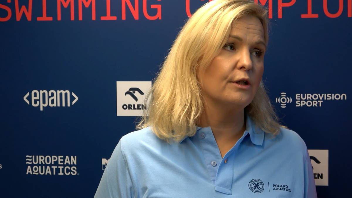 Otylia Jędrzejczak w błękitnej koszulce polo, z jasnymi blond włosami, na tle logo "EUROPEAN AQUATICS" i "ORLEN"