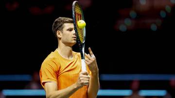 Tenisista Hubert Hurkacz z rakietą i piłką tenisową.