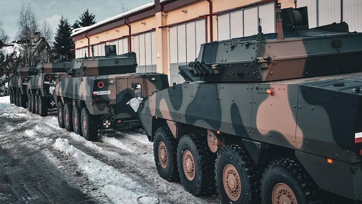 Linia pojazd&oacute;w opancerzonych w kamuflażu na zaśnieżonym placu