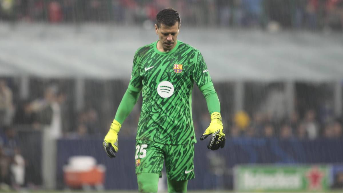 Piłkarz, bramkarz, w zielonym stroju z czarnym wzorem, żółtymi rękawicami, stoi na boisku piłkarskim.