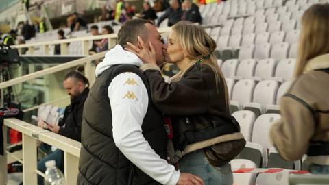 Trener Adrian Siemeniec i jego żona całujący się na tle trybun stadionu.