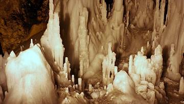 Formacje naciekowe w jaskini, przypominające lodowe stalagmity i stalaktyty.