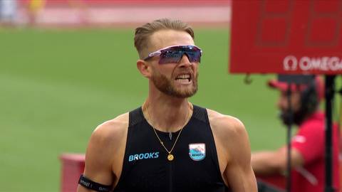 Josh Kerr, lekkoatleta w okularach przeciwsłonecznych i koszulce sportowej Brooks, biegnie podczas zawod&oacute;w.
