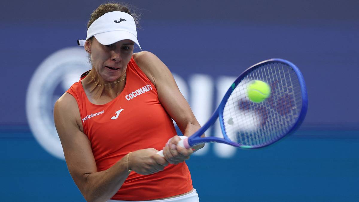 Magdalena Linette podczas meczu tenisowego, uderzająca piłkę rakietą.