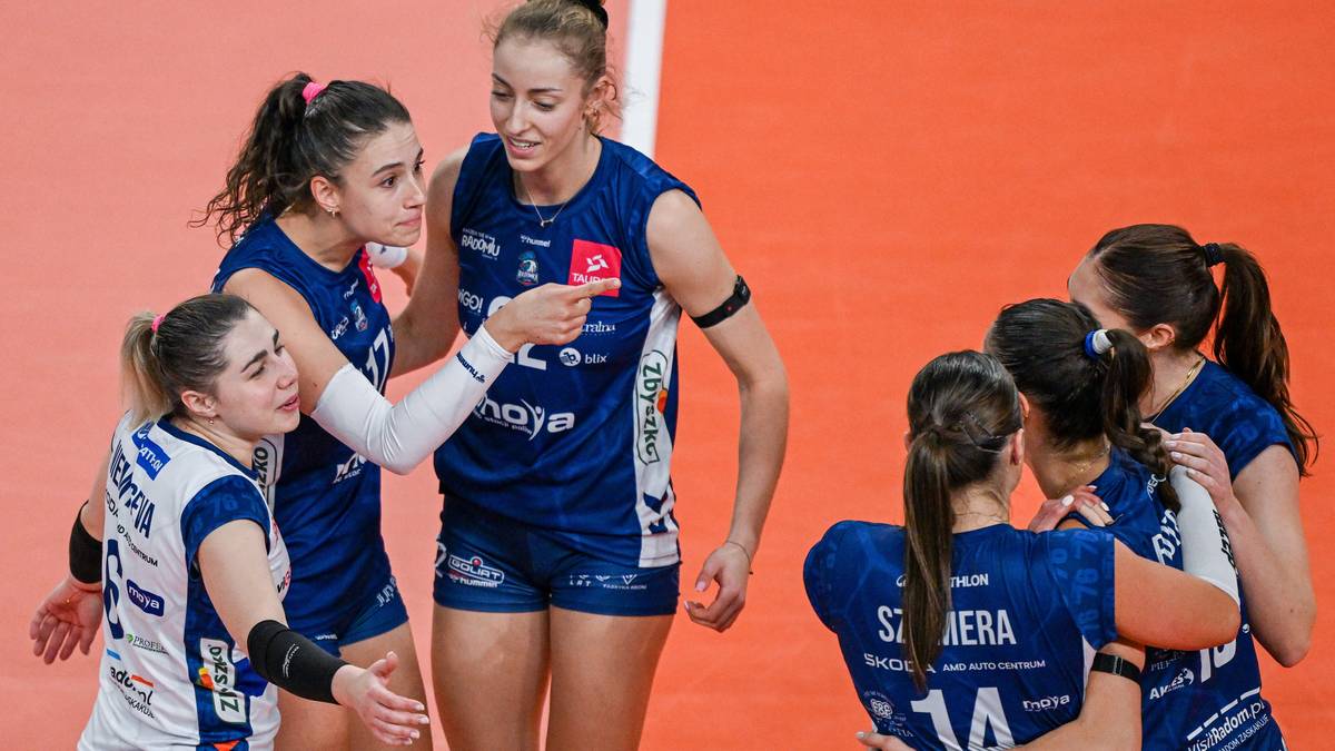 Siatkarki w niebieskich strojach świętują razem na boisku.