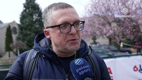 Tomasz Lorek, mężczyzna w okularach i zimowej kurtce, udziela wywiadu.