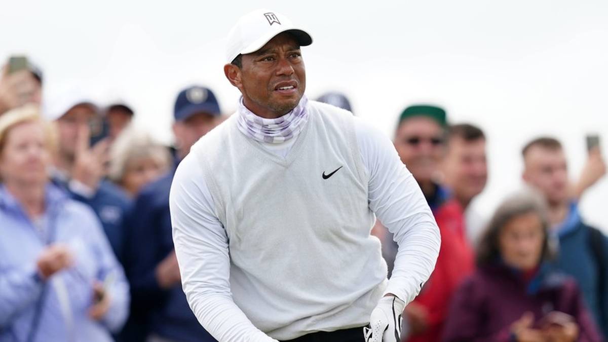 Tiger Woods w stroju golfowym stoi na tle tłumu kibic&oacute;w.