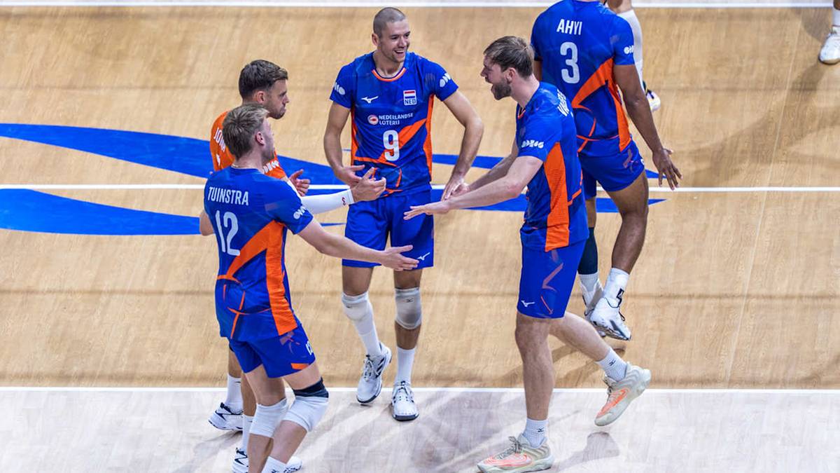 Siatkarze w niebiesko-pomarańczowych strojach świętują zwycięstwo na boisku.