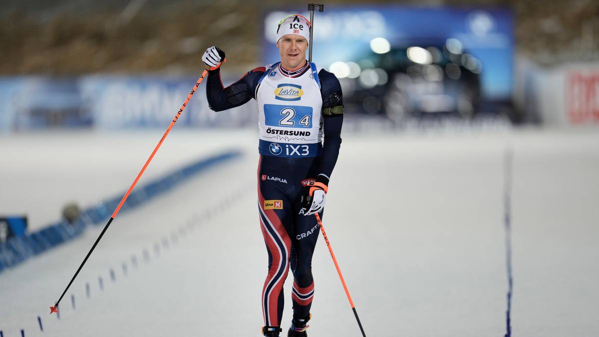 Biathlonista w stroju reprezentacji Norwegii z numerem 2 na piersi i karabinem na plecach, podczas zawodów na śniegu.