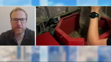 Mężczyzna w okularach po lewej, po prawej fragment maszyny z materiałem i ręka z zegarkiem.