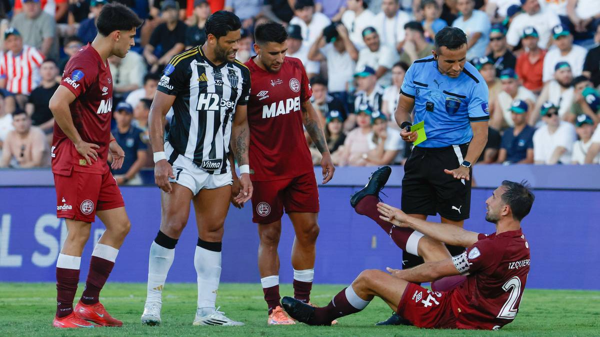Piłkarze Lanus i Atletico Mineiro na boisku podczas meczu finałowego Copa Sudamericana, z sędzią i leżącym zawodnikiem.