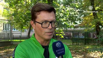 Bożydar Iwanow w zielonej bluzie i czarnych okularach udziela wywiadu na tle zieleni.