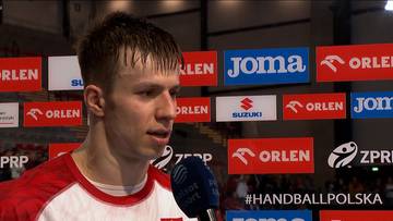 Michał Olejniczak, kapitan, w wywiadzie na tle sponsorów.