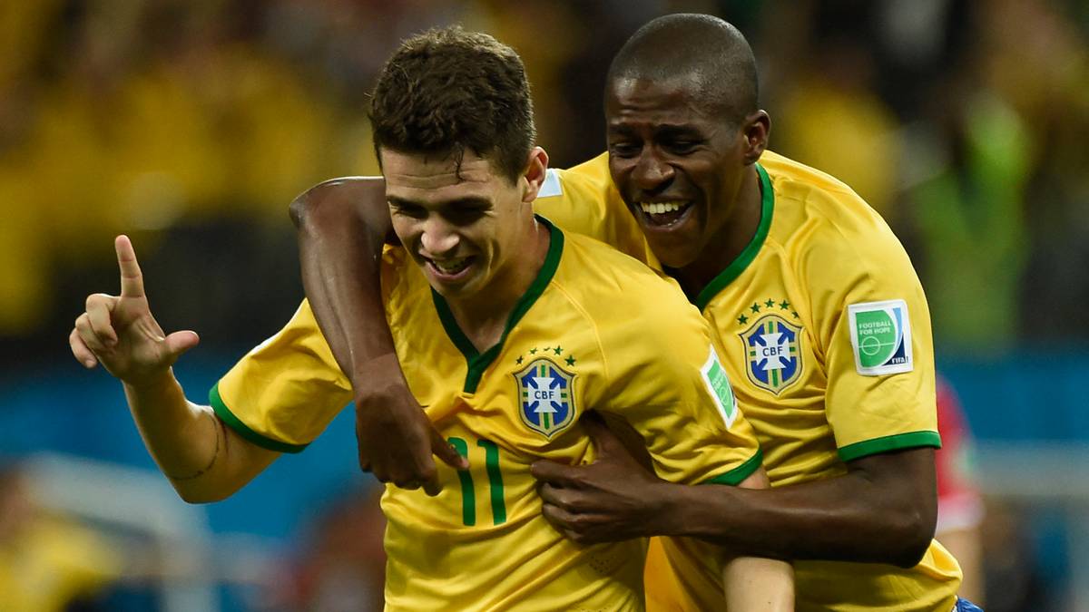 Dwóch piłkarzy reprezentacji Brazylii cieszących się z gola, jeden z nich obejmuje kolegę i wskazuje palcem w górę.