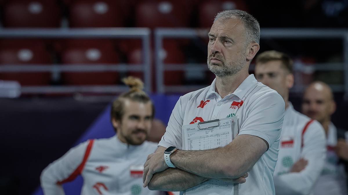 Sztab szkoleniowy polskiej drużyny siatkarskiej podczas meczu, z trenerem na pierwszym planie wpatrzonym w dal.