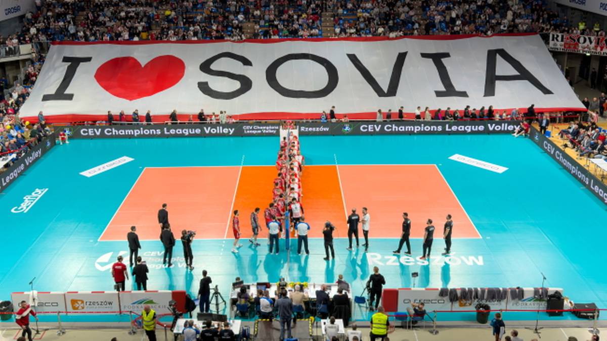 Transparent z napisem "I ❤️ SOVIA" nad boiskiem siatkarskim, z zawodnikami ustawionymi na środku