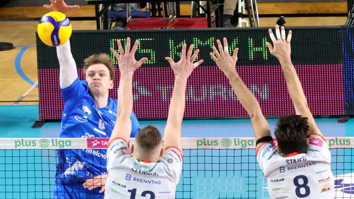 Siatkarz wykonujący zagrywkę podczas meczu siatkówki.