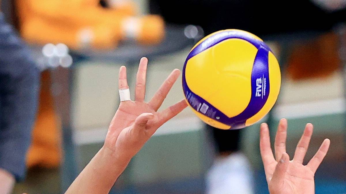 Siatkarze podczas akcji przy siatce, jeden z graczy pr&oacute;buje zablokować atak przeciwnika.