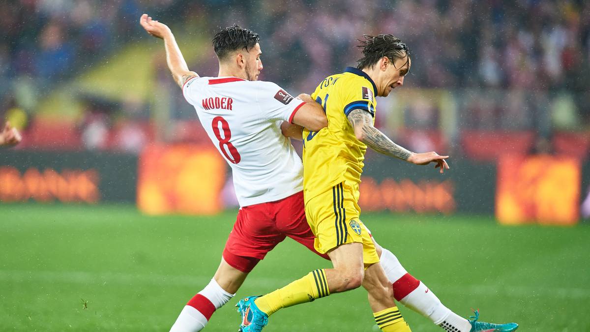 Dw&oacute;ch piłkarzy rywalizuje o piłkę na boisku.