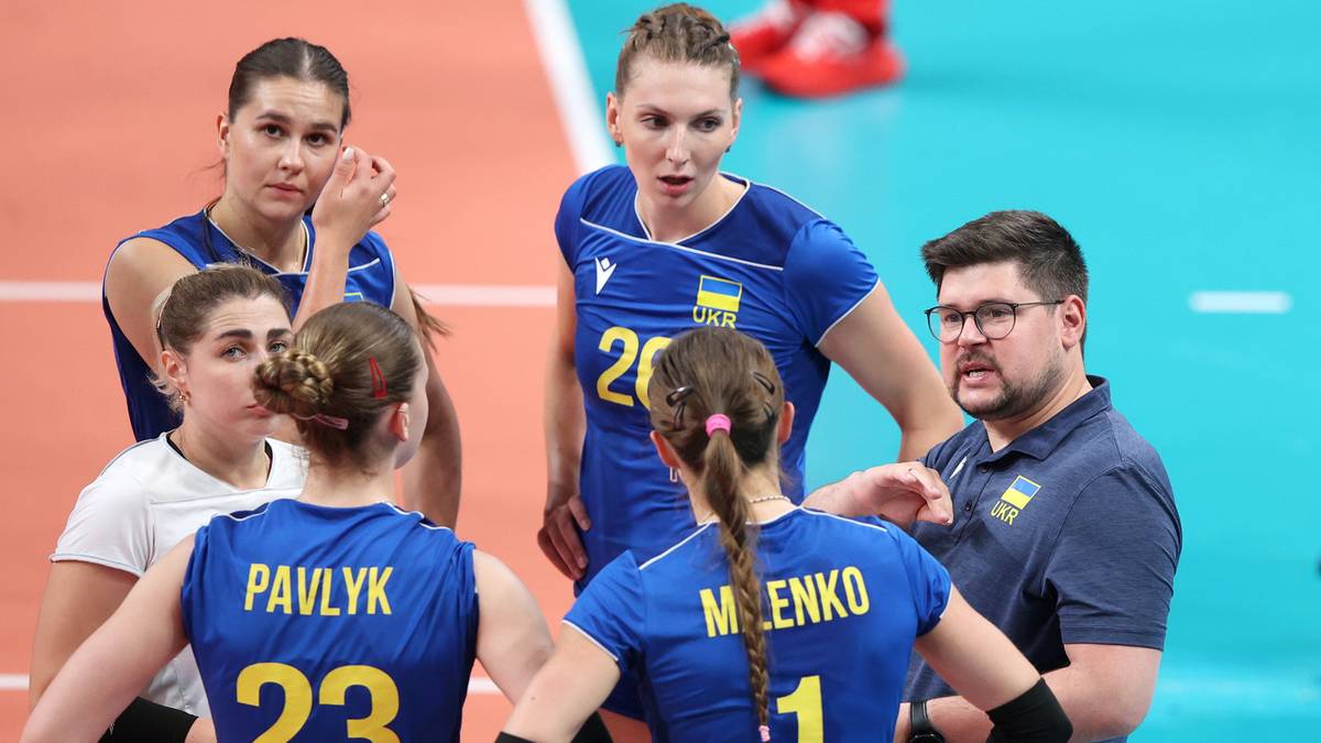 Siatkarki reprezentacji Ukrainy w niebiesko-żółtych strojach podczas treningu, otoczone przez trenera.