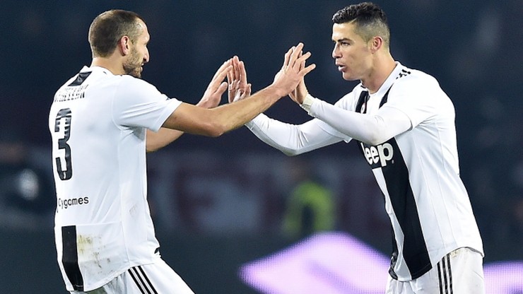 Cristiano Ronaldo i Giorgio Chiellini z Juventusu celebrują zwycięstwo, wykonując wysokie piątki.