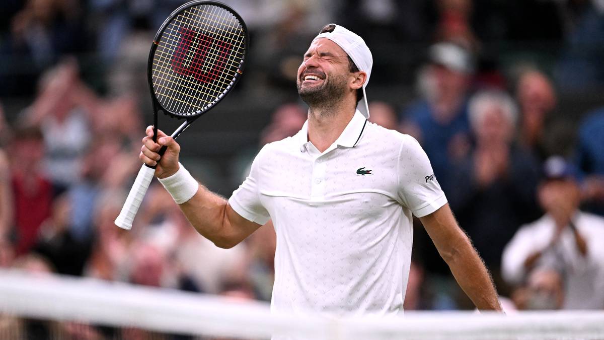 Grigor Dimitrow, tenisista, świętuje zwycięstwo na Wimbledonie, trzymając rakietę tenisową i patrząc w g&oacute;rę.