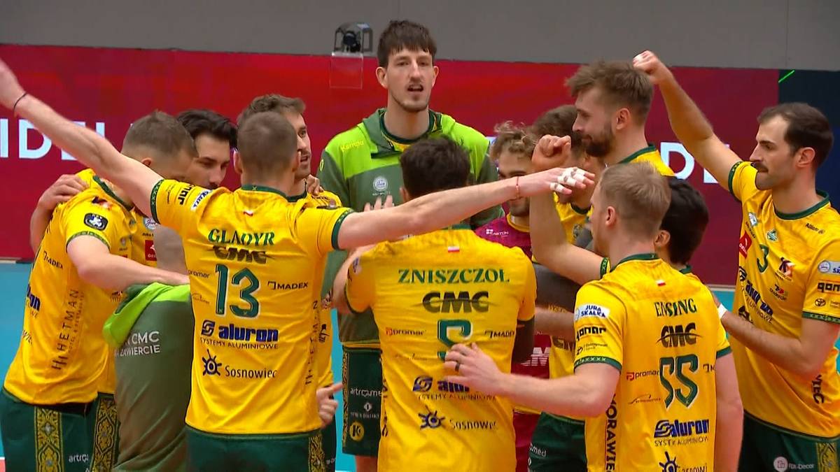 Siatkarze Aluron CMC Warta Zawiercie świętujący zwycięstwo, obejmując się i ciesząc się na boisku.