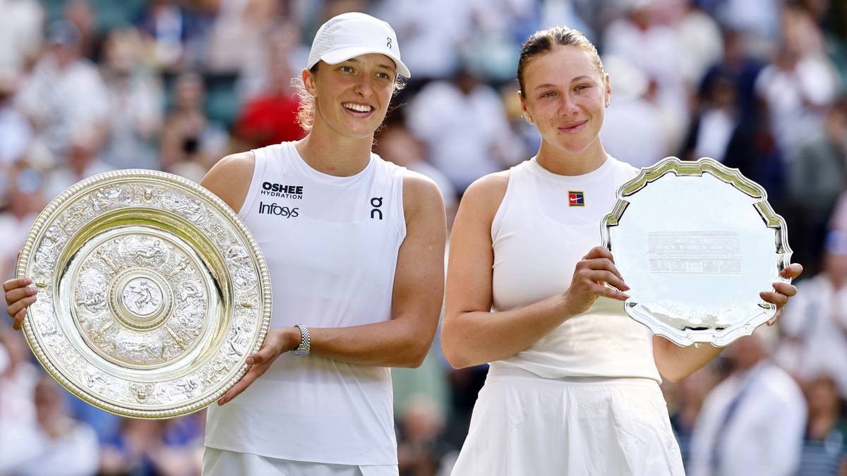 Dwie tenisistki na tle publiczności trzymają puchary.