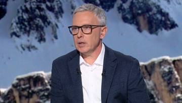 Mężczyzna w okularach i marynarce, na tle gór.