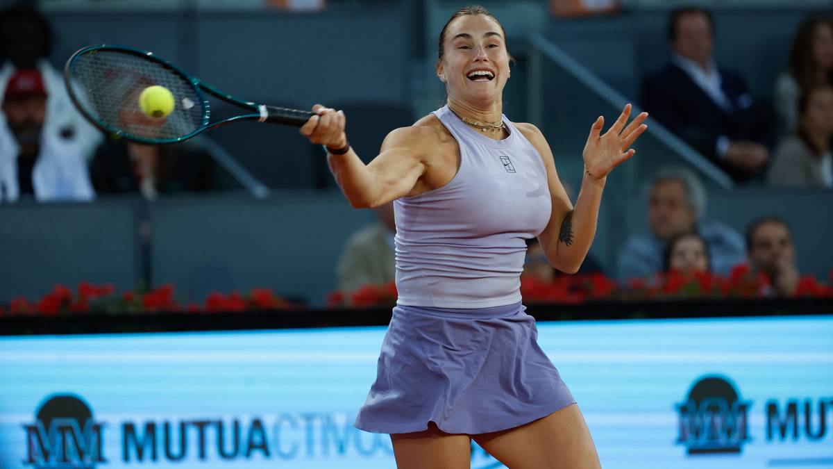 Aryna Sabalenka podczas meczu tenisowego, w akcji, z rakietą w ręku i piłką w powietrzu.