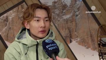 Młody mężczyzna o azjatyckich rysach, ubrany w jasnoszarą kurtkę, udziela wywiadu z mikrofonem Polsat Sport. W tle widoczny g&oacute;rski krajobraz ze śniegiem.