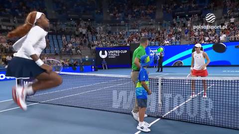 Iga Świątek w skoku do odbicia piłki tenisowej podczas meczu z Coco Gauff, na korcie tenisowym z publicznością na trybunach.