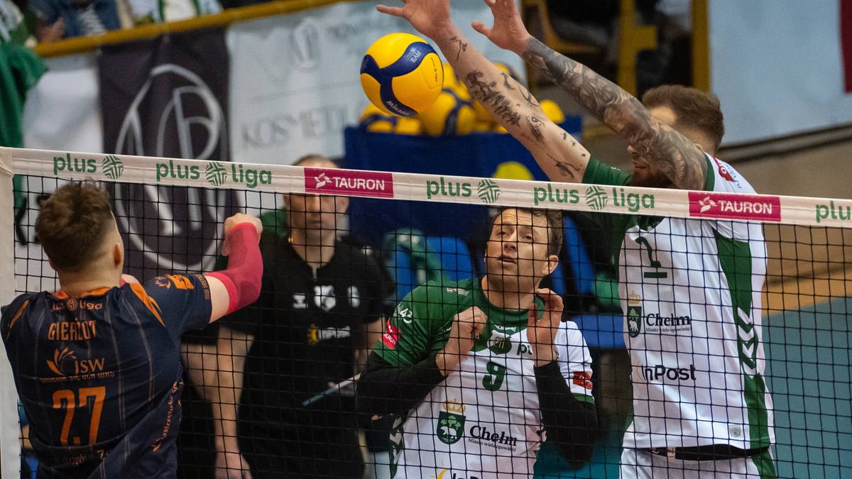 Siatkarze podczas meczu siatk&oacute;wki, jeden z zawodnik&oacute;w wykonuje blok, piłka leci w kierunku boiska.