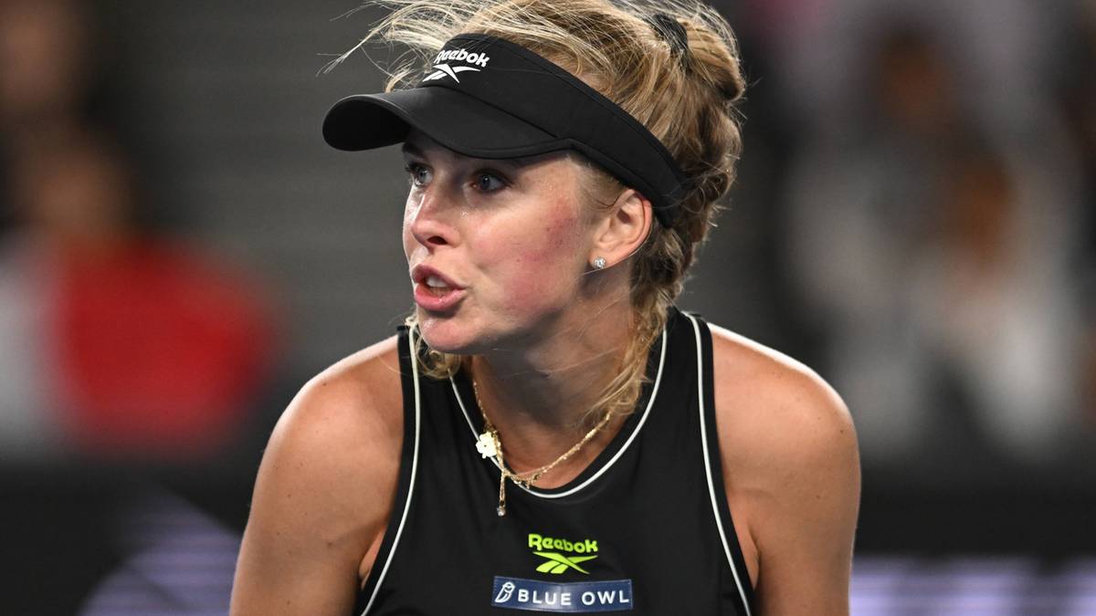 Portret tenisistki Magdaleny Fręch podczas meczu, noszącej czarną czapkę z daszkiem i czarny top sportowy.