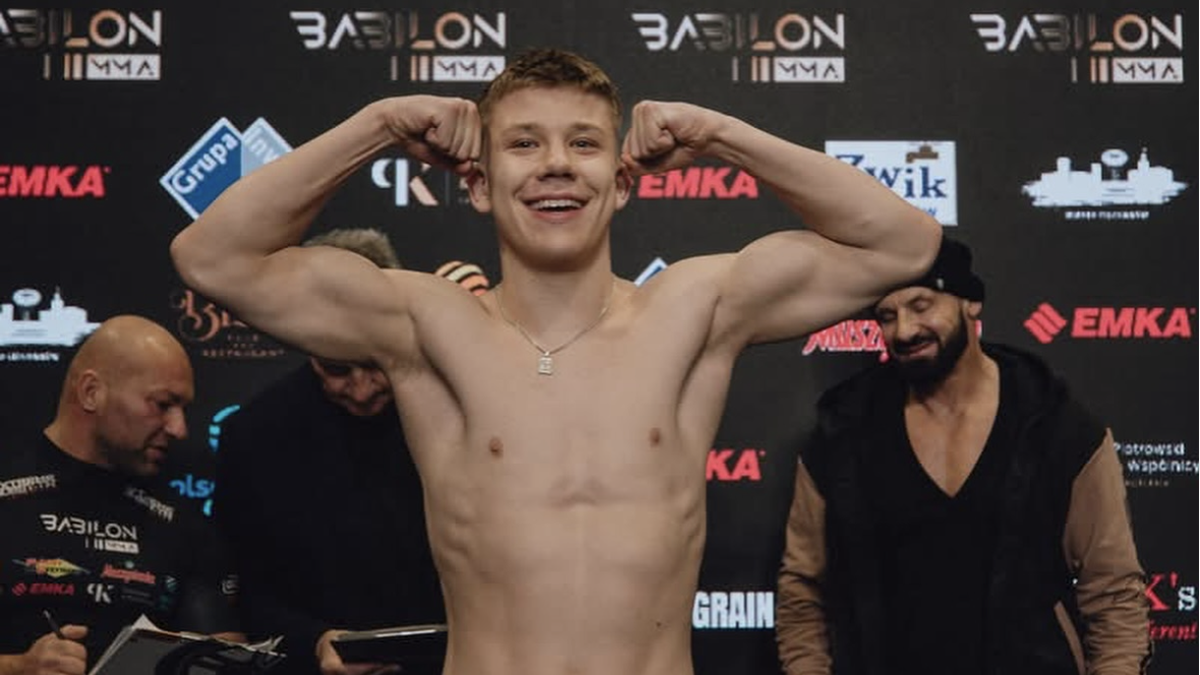 Młody zawodnik sportów walki napina mięśnie bicepsów przed galą Babilon MMA.