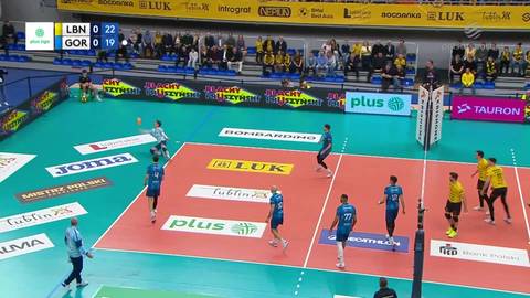 Fragment meczu siatk&oacute;wki, zawodnicy w akcji na boisku, tablica wynik&oacute;w z wynikiem LBN 22 - GOR 19.