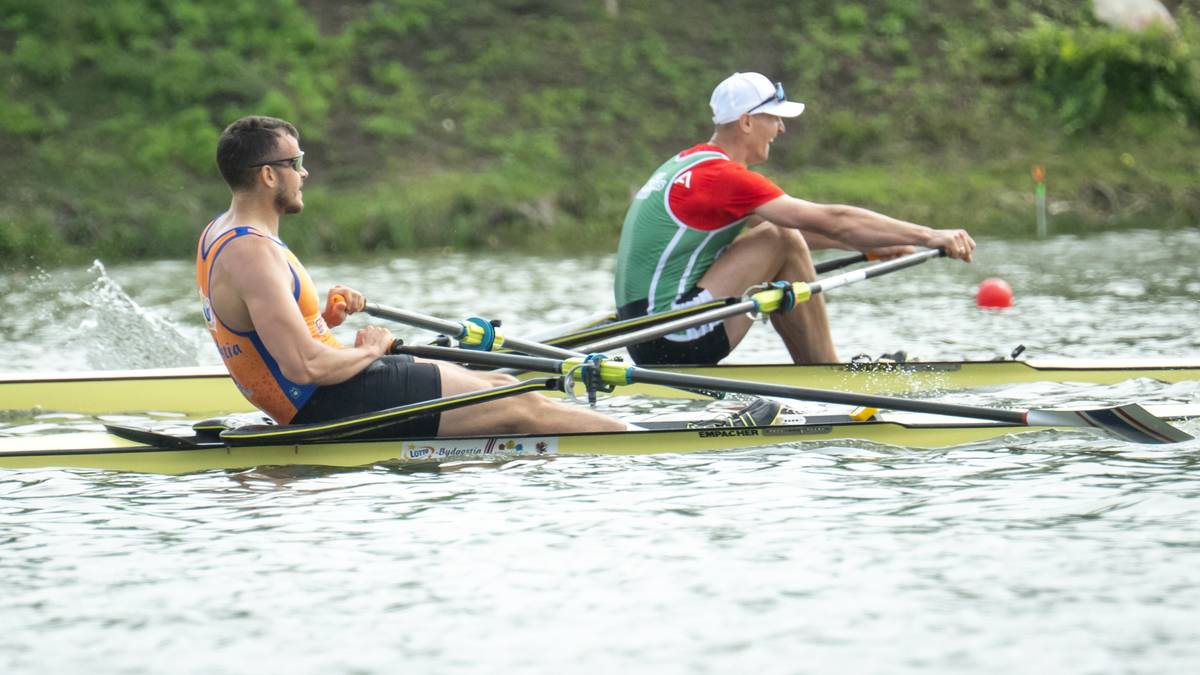 Dwóch wioślarzy w łodzi podczas zawodów, jeden z nich trzyma wiosło, drugi patrzy w przód.