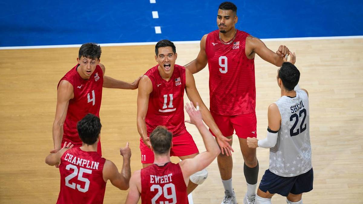 Sześciu siatkarzy w czerwonych i białych strojach rywalizuje na boisku.