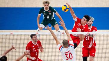 Siatkarze rywalizujący przy siatce podczas meczu siatk&oacute;wki.