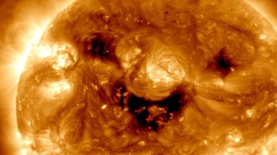 Uśmiechnięta buźka Słońca to trzy dziury koronalne. Fot. NASA / SDO.