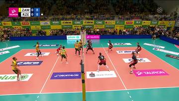 Mecz siatkówki pomiędzy Aluron CMC Wartą Zawiercie a Asseco Resovią Rzeszów. Gracze walczą o piłkę na boisku, a na ekranie widoczny jest wynik.