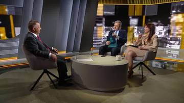 Trzy osoby siedzą przy okrągłym stole w studiu telewizyjnym, dyskutując. Po lewej mężczyzna w garniturze, pośrodku mężczyzna z dokumentem, po prawej kobieta w jasnej garsonce.