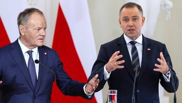 Donald Tusk i Karol Nawrocki rozmawiają na tle polskich flag
