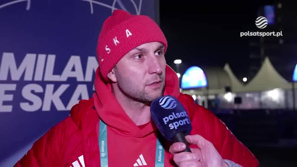 Mężczyzna w czerwonej czapce i kurtce z kapturem, m&oacute;wiący do mikrofonu "polsatsport".