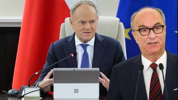 Dw&oacute;ch mężczyzn w eleganckich strojach siedzących przy stole konferencyjnym, z flagami Polski i Unii Europejskiej w tle.