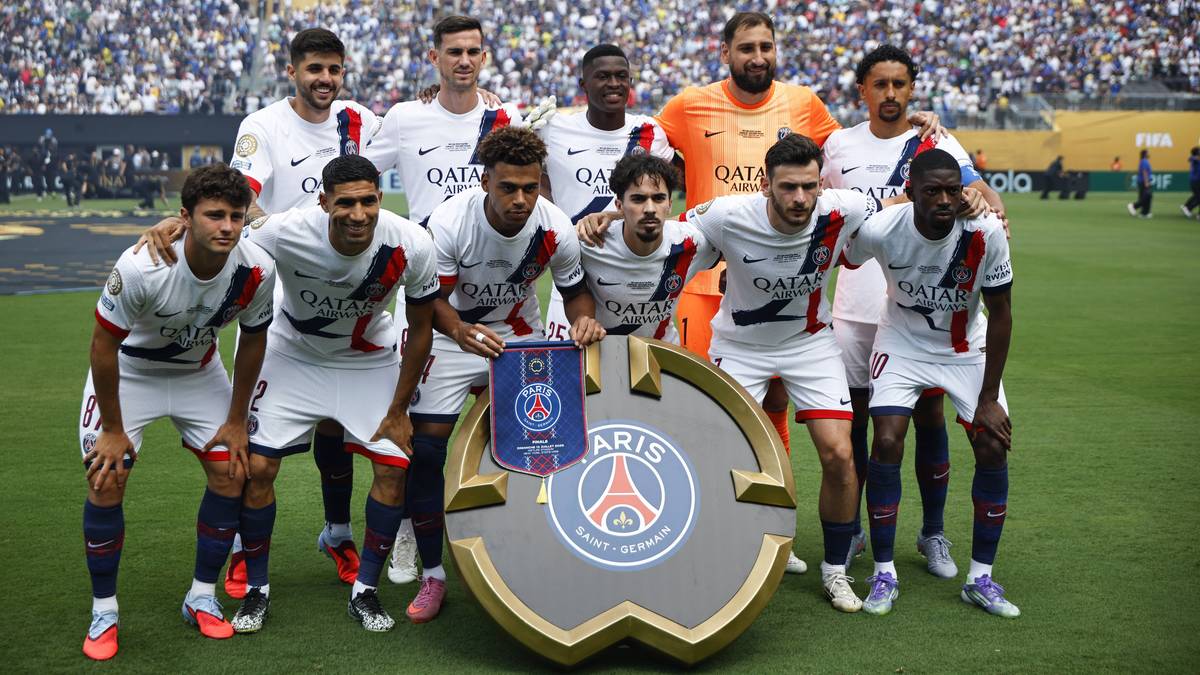 Drużyna piłkarska PSG pozująca do zdjęcia z pucharem.
