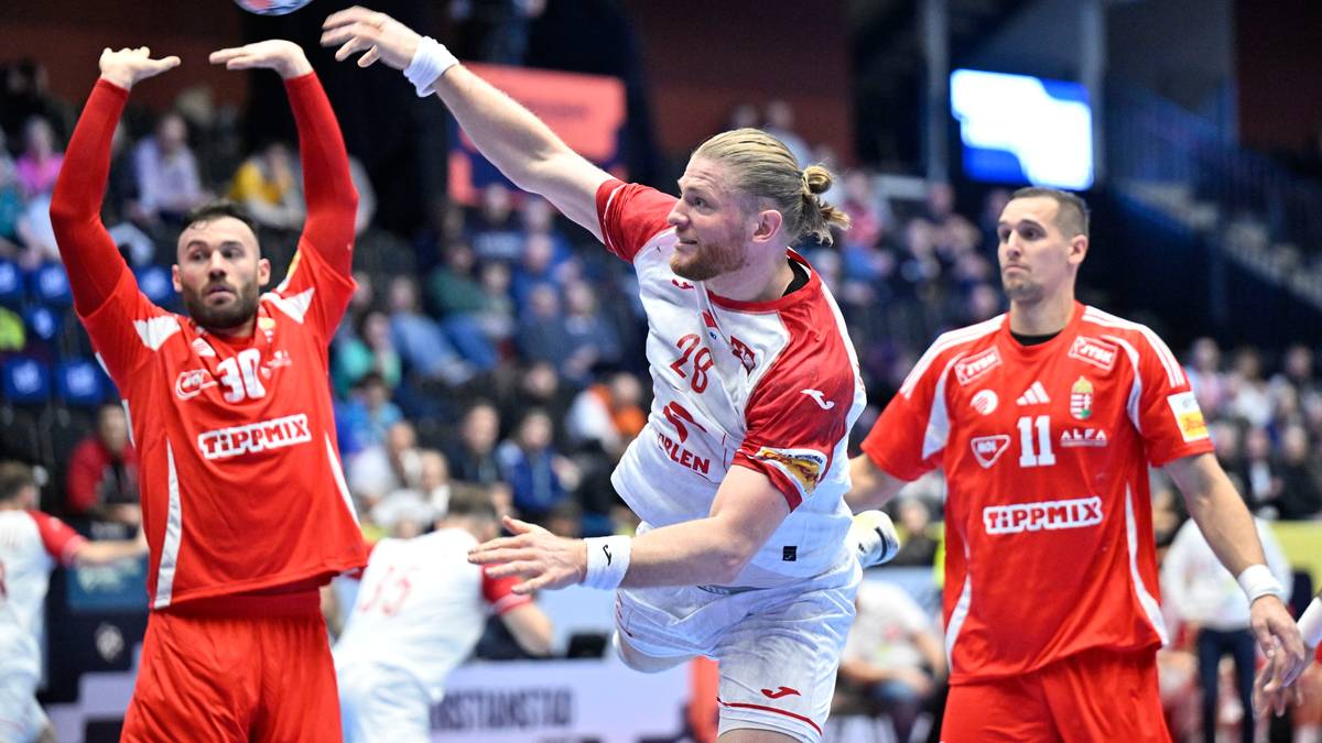 Trzech mężczyzn w strojach sportowych grających w piłkę ręczną. Jeden z nich rzuca piłkę do g&oacute;ry, drugi pr&oacute;buje ją złapać, a trzeci stoi z boku.